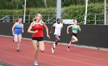jenter løper 100 meter sprint på Nordisk skoleidrettsstevne
